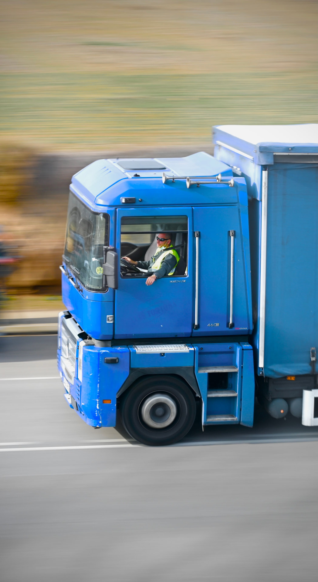 Caminhão azul em movimento na rodovia — operador logístico regional atendido pela Vale IT Solutions.