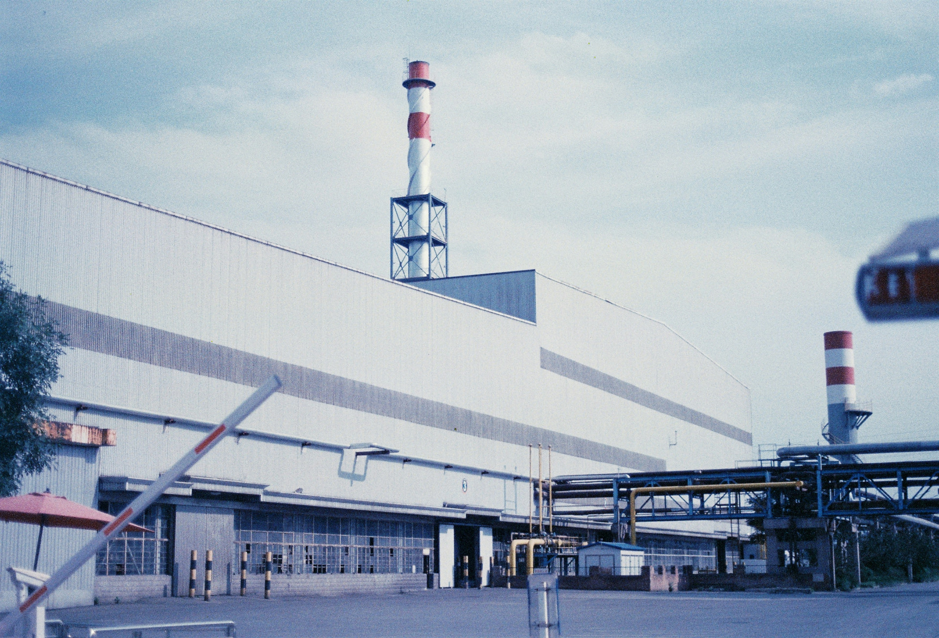 Planta industrial de manufatura com galpão e chaminés — ambiente produtivo atendido pela Vale IT Solutions.